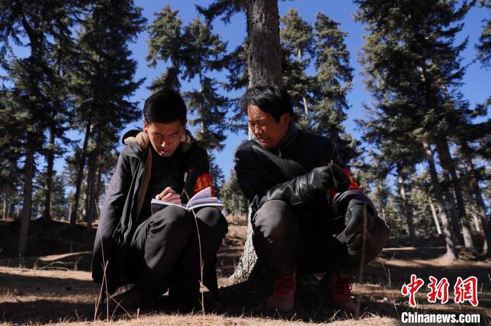 圖為桑杰加(左)和同事記錄巡查結(jié)果?！●R銘言 攝