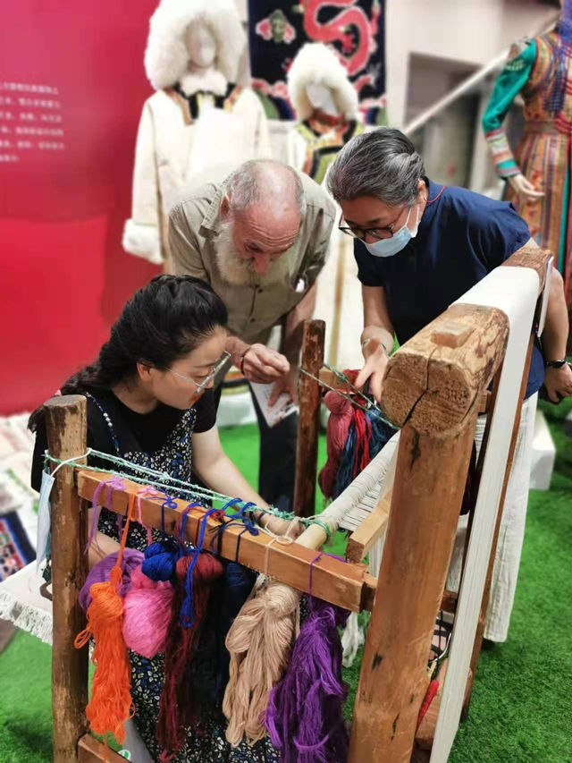 楊永良的學(xué)生在展會上向客商介紹加牙藏毯編織技藝。受訪者供圖