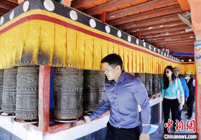 圖為外籍嘉賓體驗藏族傳統(tǒng)轉(zhuǎn)經(jīng)筒?！●R銘言 攝