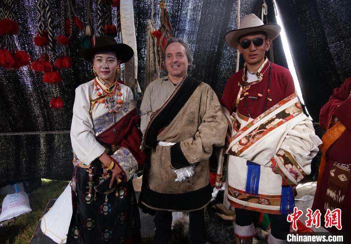 圖為一名外籍攝影師(中)身穿藏服和藏族民眾合影留念?！●R銘言 攝