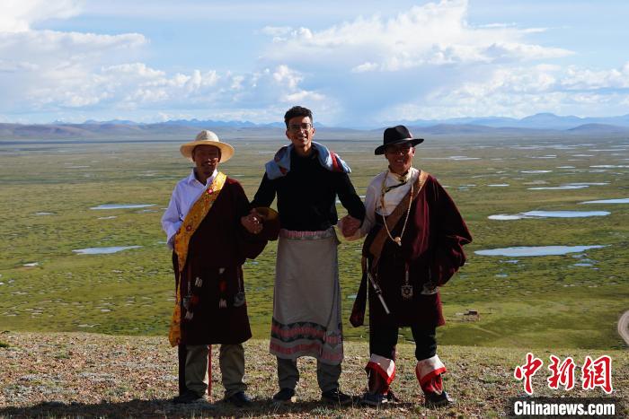 圖為一名留學(xué)生身穿自己國家的服飾和藏族民眾合影留念。　馬銘言 攝