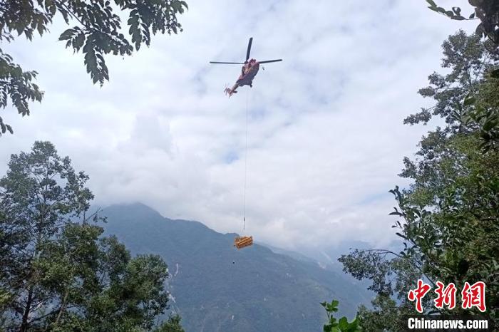 直升機起飛將搶修塔材運往海拔1950米的110千伏唐下線29號塔位?！⌒鞈c明 攝