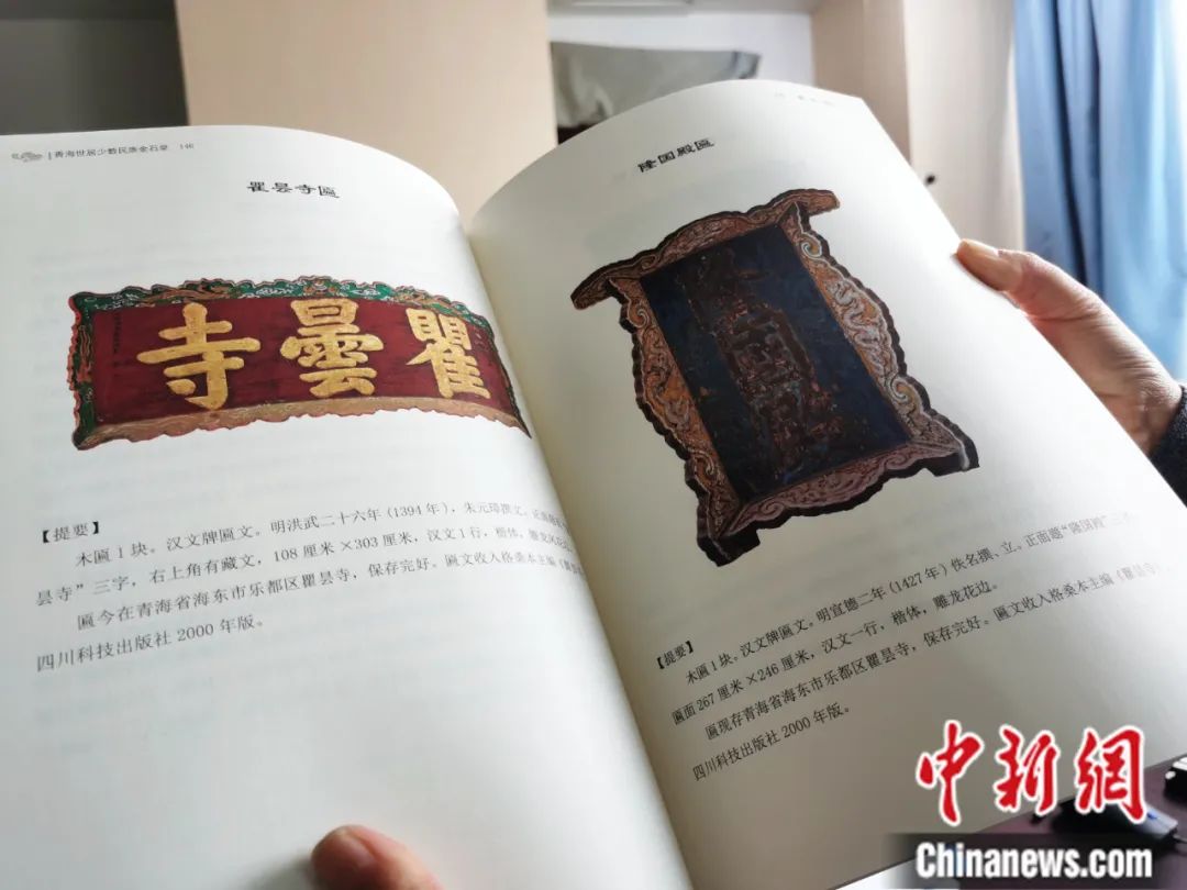 古籍保護(hù)人員展示介紹明代朱元璋撰寫的青海瞿曇寺匾(左)的出版書籍。張?zhí)砀?攝
