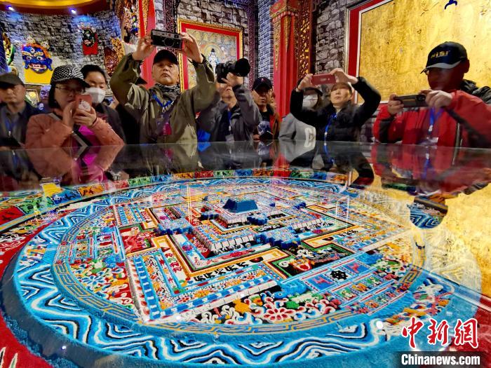 圖為參觀者拍攝壇城?！?zhí)砀?攝