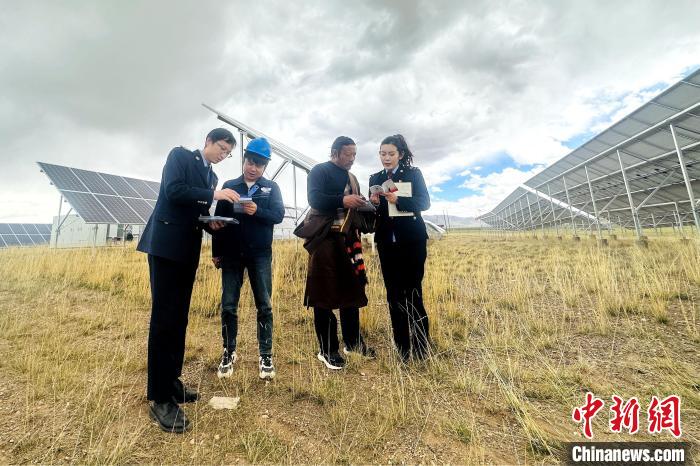 圖為稅務(wù)干部上門開展稅費輔導(dǎo)?！》劫F龍 攝