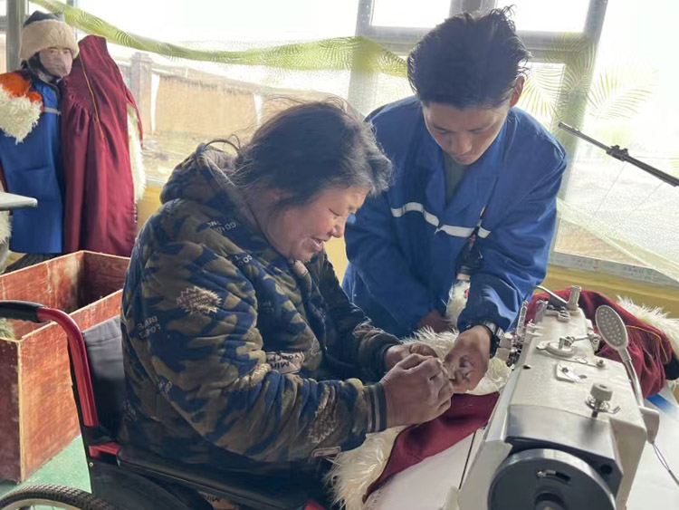 扎西奪爾登幫助殘疾員工裁剪。阿壩州文明辦供圖