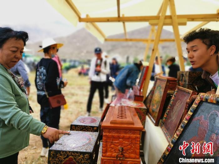 圖為拉薩市民在特色農(nóng)畜產(chǎn)品展示展銷會上選購商品?！垈?攝