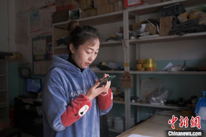 正在快遞站點內(nèi)忙碌的楊莉春?！『闻罾?攝