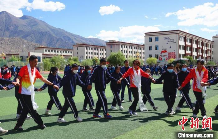 圖為世界冠軍與拉薩阿里地區(qū)高級中學(xué)學(xué)生一起跳鍋莊?！∪轿木?攝