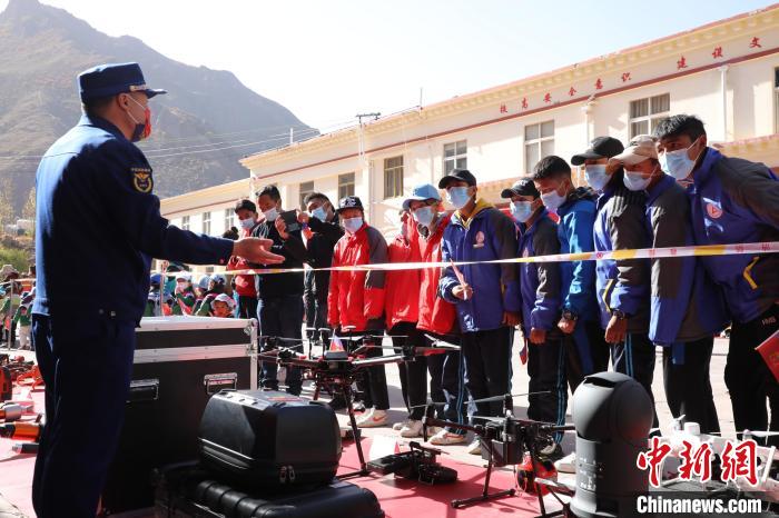 圖為消防指戰(zhàn)員為學(xué)生講解、演示先進(jìn)救援裝備。　趙琳 攝