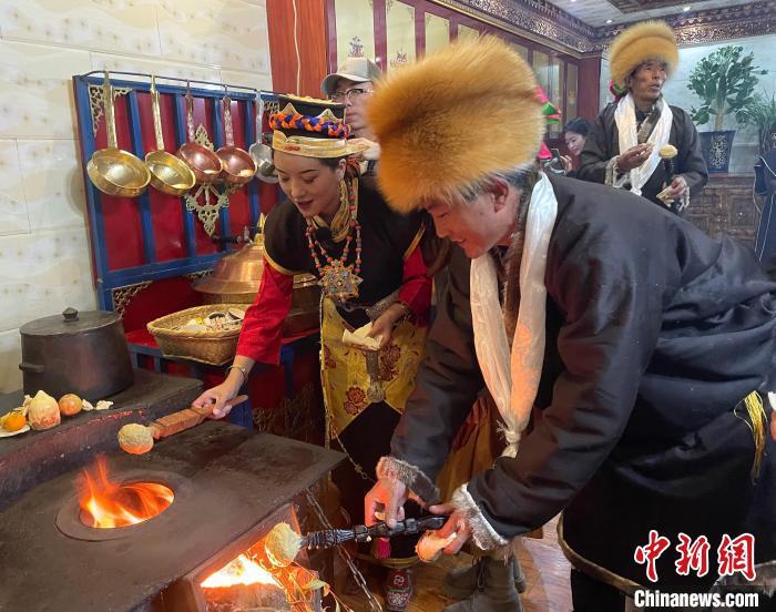 圖為人們?cè)诨鹕峡竟?jié)日美食“結(jié)達(dá)”?！∪轿木?攝