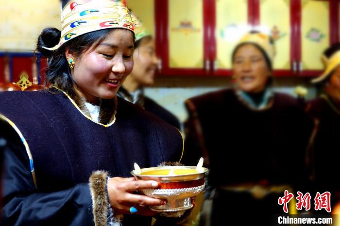 圖為藏族姑娘向客人敬酒?！∪轿木?攝
