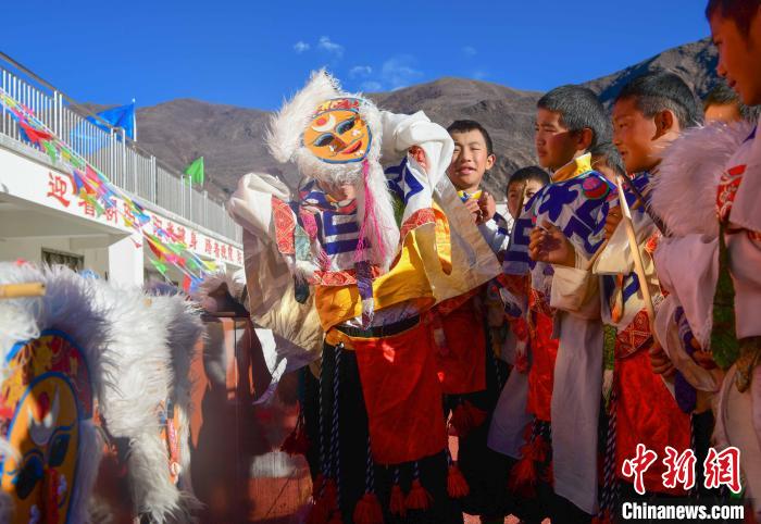 圖為加查縣安繞鎮(zhèn)小學(xué)學(xué)生在試穿藏戲面具?！∝暩聛硭?攝