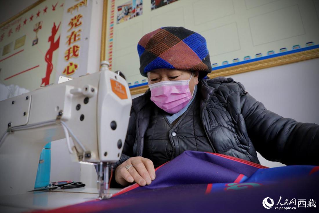 農(nóng)牧民專業(yè)合作社里的村民正在制作門簾。人民網(wǎng) 次仁羅布攝