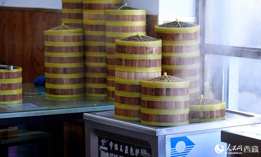 電蒸箱上擺滿了多屜熱氣騰騰的包子。人民網(wǎng) 次仁羅布攝