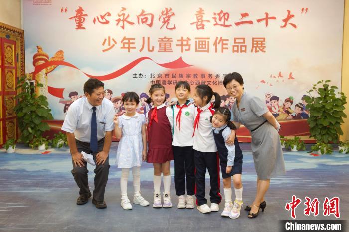 圖為與會嘉賓與入選畫作的“小作者”們在展覽上合影?！≈袊貙W研究中心供圖