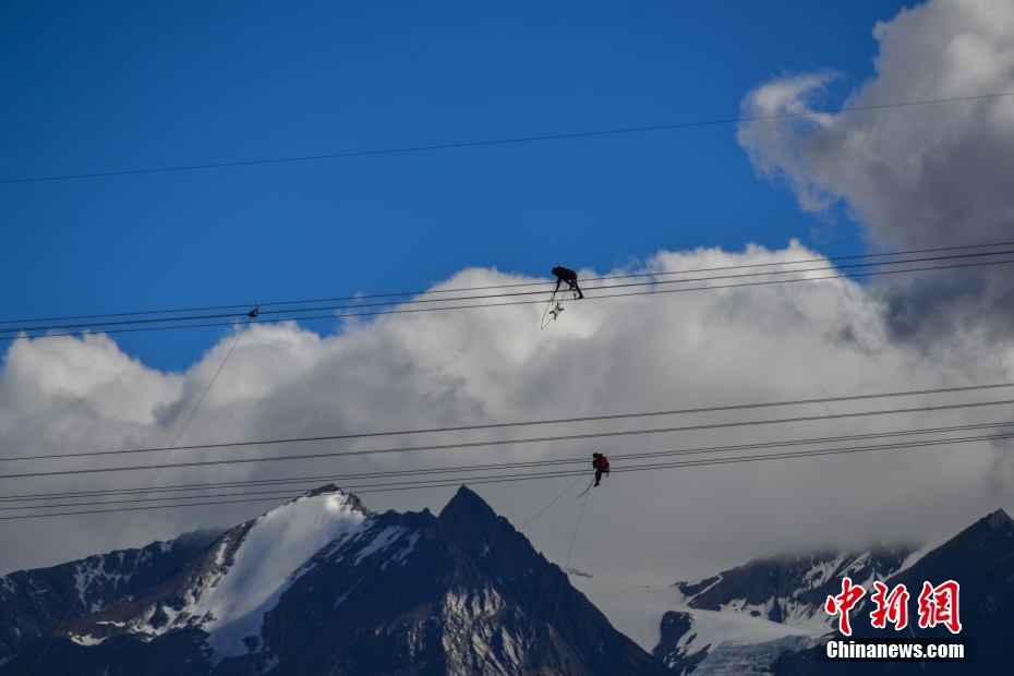 資料圖為2020年6月23日，西藏阿里聯(lián)網(wǎng)工程施工人員在日喀則希夏邦馬雪山附近進(jìn)行走線(xiàn)作業(yè)，安裝絕緣設(shè)備。 <a target='_blank' href='/'><p  align=