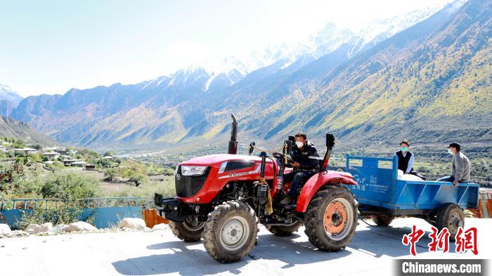 圖為工作人員將把加工完成的糌粑運(yùn)送至村民手中。　嘉黎縣融媒體中心供圖