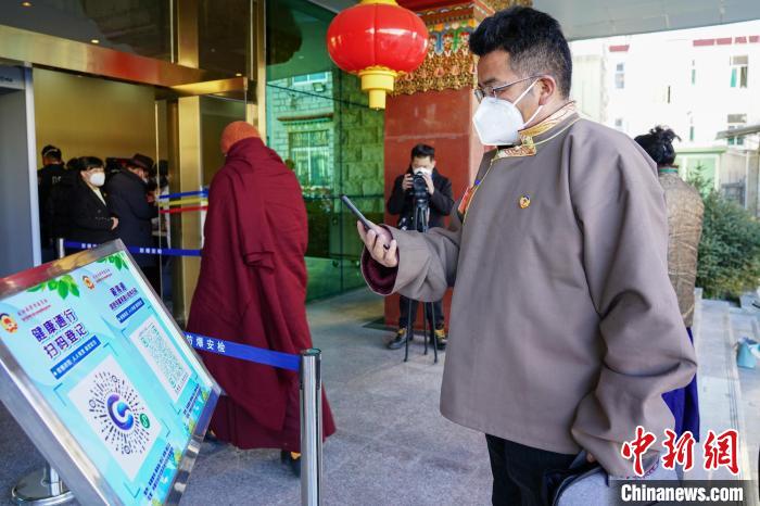 圖為政協(xié)委員掃場所碼進(jìn)入會(huì)場?！〗w波 攝