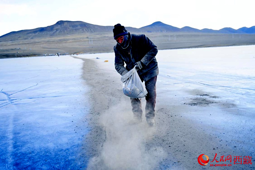 牧民在冰面上撒灰鋪成通道。人民網(wǎng) 李海霞攝
