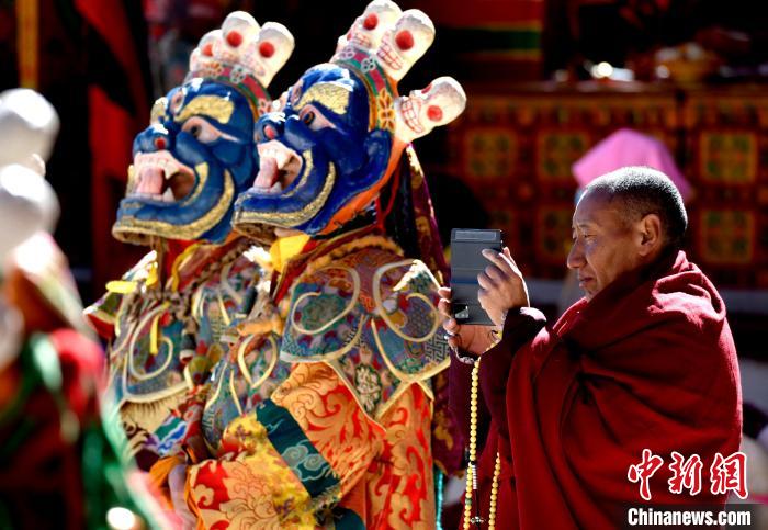 2月19日，正在拍攝跳神活動(dòng)的僧人?！±盍?攝