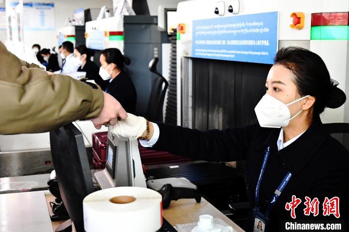 圖為機(jī)場工作人員為旅客辦理行李托運(yùn)?！≈芎?攝