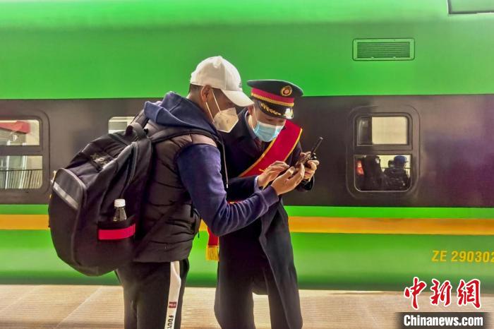 圖為日喀則火車站工作人員服務(wù)乘客。　斗山得 攝