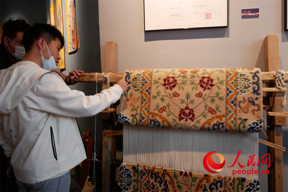 觀眾正在觀賞展出的藏毯。人民網(wǎng) 韋衍行攝