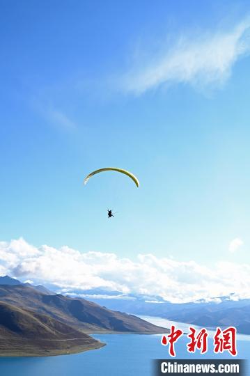 圖為在羊卓雍錯(cuò)，游客體驗(yàn)高空滑翔。　趙朗 攝