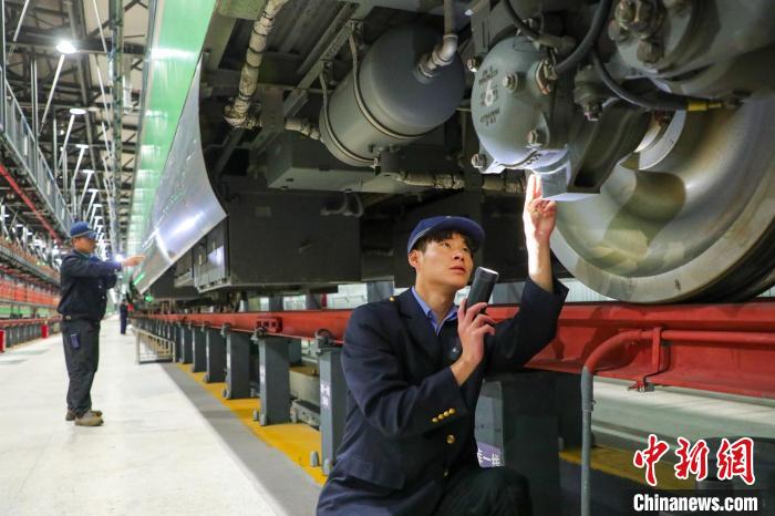 圖為工作人員檢查高原復(fù)興號(hào)?！≈軔傁?攝