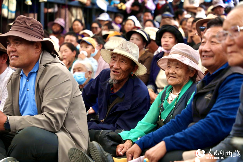 當(dāng)?shù)厝罕姾陀慰陀^看藏戲演出。