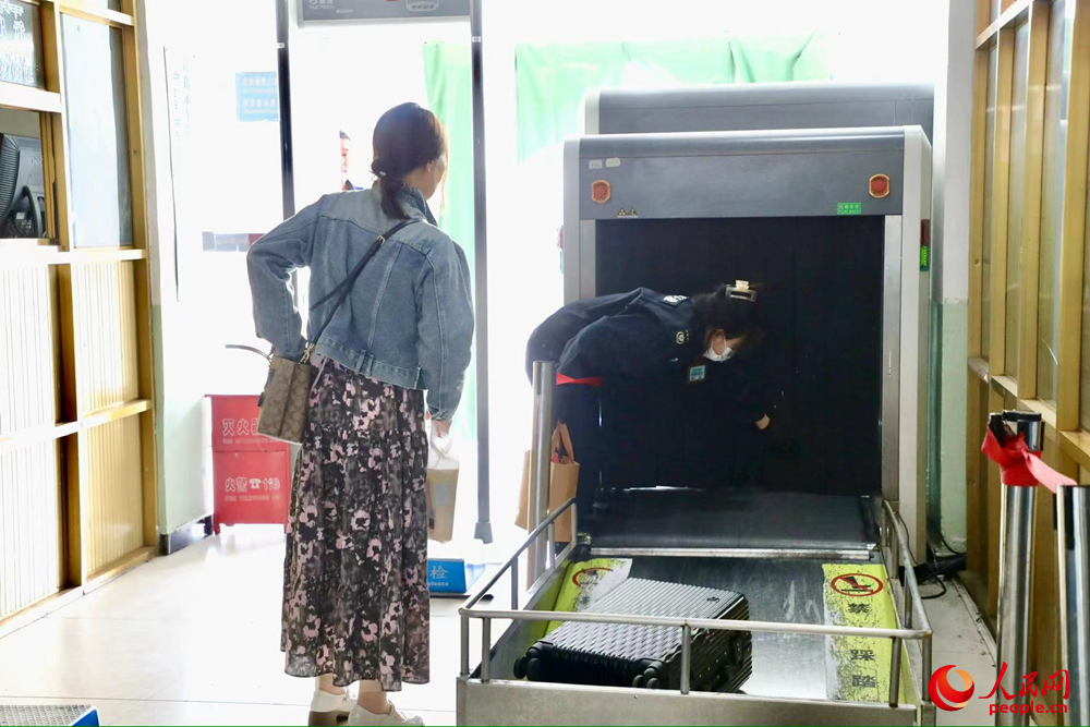 車(chē)站工作人員幫旅客提取行李。人民網(wǎng)記者 次仁羅布攝