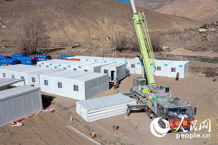 1月9日，在日喀則市定日縣長(zhǎng)所鄉(xiāng)古榮村安置點(diǎn)，救援人員和施工人員合力抓緊搭建移動(dòng)板房，確保受災(zāi)群眾溫暖過(guò)冬。人民網(wǎng)記者 翁奇羽攝