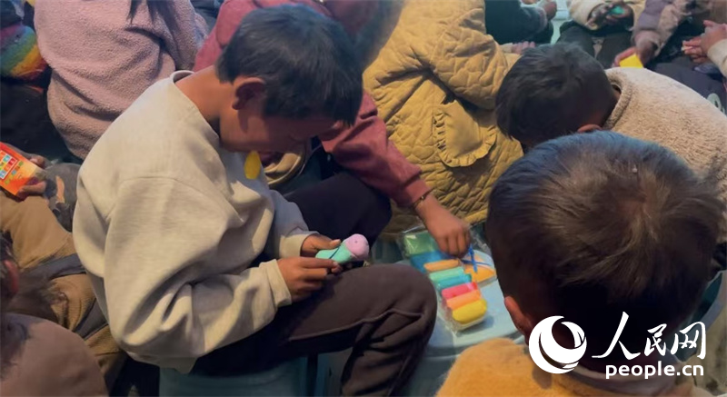 措果鄉(xiāng)塘仁村的孩子們正在用橡皮泥制作自己的情緒“小怪獸”。人民網(wǎng)記者 郝潔攝