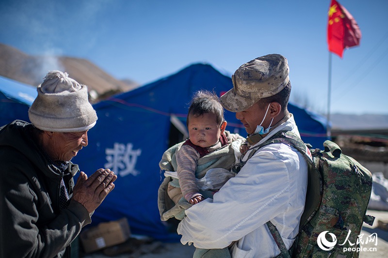 1月9日，在定日縣長所鄉(xiāng)古榮村安置點，受災群眾感謝西藏軍區(qū)陸軍某部隊衛(wèi)生員的醫(yī)療救治。人民網(wǎng)記者 翁奇羽攝