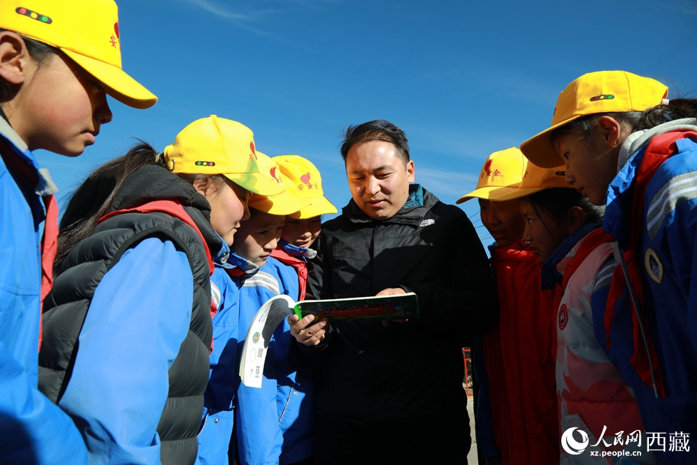 西藏自治區(qū)藏醫(yī)院專家為拉東村小學生講解天文歷算原理，孩子們圍站聆聽，感受傳統(tǒng)智慧與現(xiàn)代科普的融合。人民網(wǎng)記者 吳雨仁攝