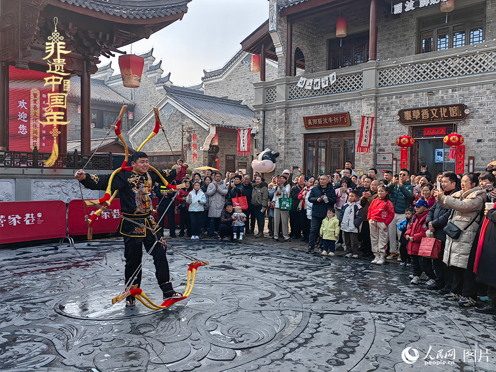 2025年1月29日，湖北襄陽(yáng)市管家巷，老北京天橋大刀張舉大刀拉硬弓第五代傳承人現(xiàn)場(chǎng)表演，一次拉開(kāi)6張弓，引來(lái)游客喝彩。人民網(wǎng)記者 郭婷婷攝