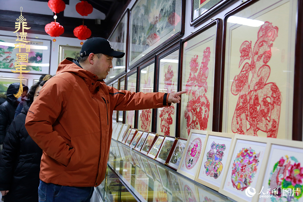 2025年1月23日，游客在天津楊柳青古鎮(zhèn)欣賞傳統(tǒng)剪紙作品，感受指尖上的古老藝術(shù)。人民網(wǎng)記者 崔新耀攝