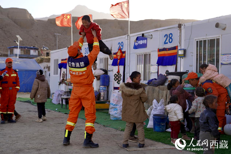 熱木青村安置點，消防員們同孩子們嬉戲玩耍。人民網記者 次仁羅布攝