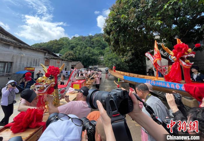 圖為5月29日，長(zhǎng)樂江田鎮(zhèn)村民為即將入水的新龍舟安裝龍頭。　張斌 攝