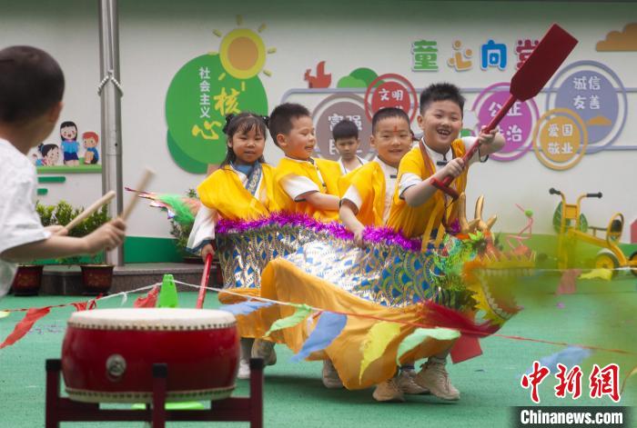 圖為龍舟賽游戲上，小伙伴們打鼓加油。　董觀生 攝